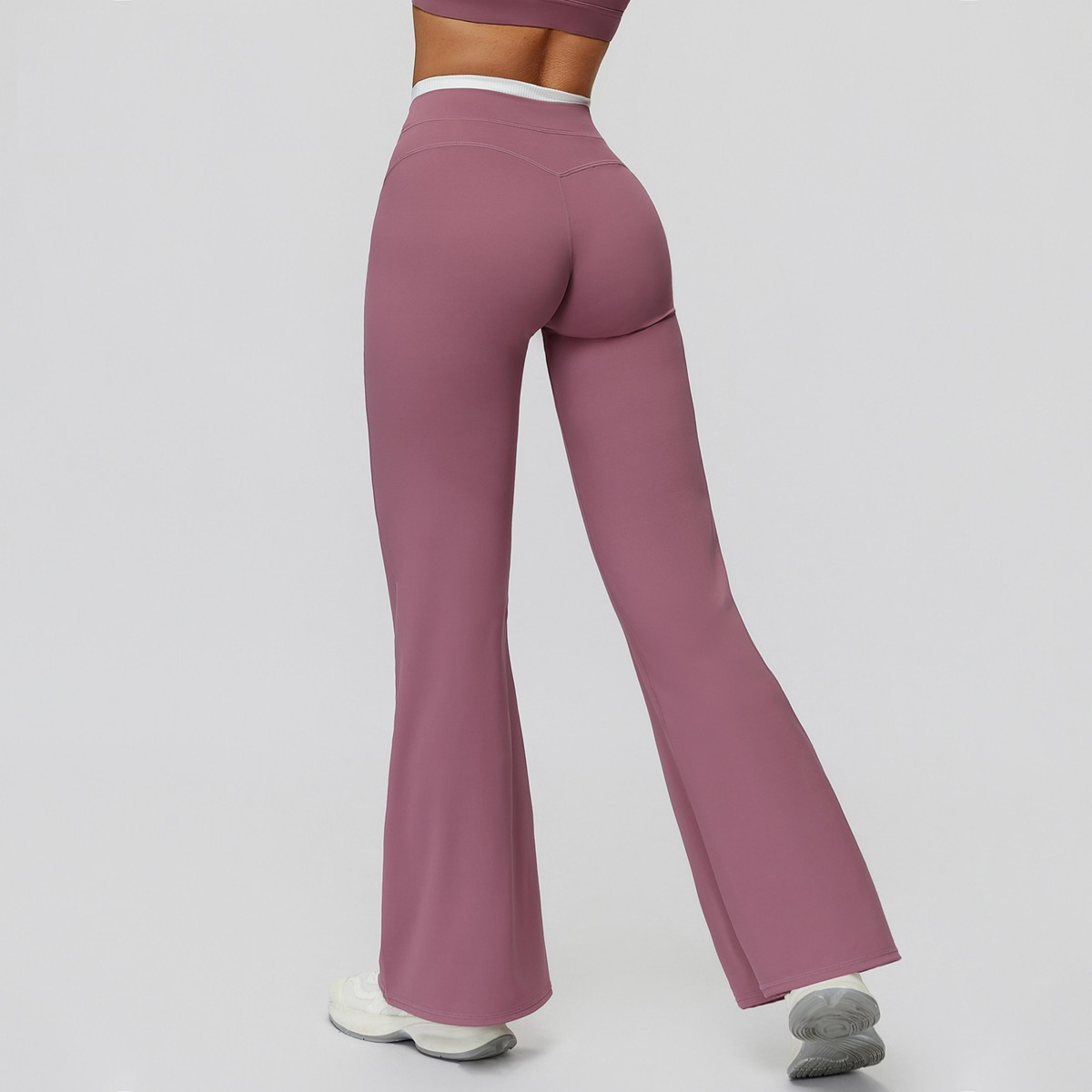 Purple flared pants worn by a person on a plain background